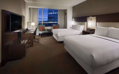 Day use twin room with workspace and lounge seating at Hilton Dallas/ Plano Granite Park.