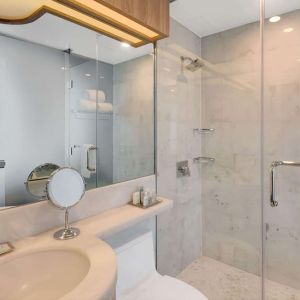 Private guest bathroom with shower and free toiletries at Wyndham Garden Brooklyn Sunset Park.