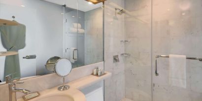Private guest bathroom with shower and free toiletries at Wyndham Garden Brooklyn Sunset Park.