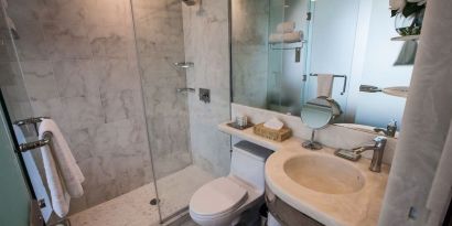 Private guest bathroom with shower and free toiletries at Wyndham Garden Brooklyn Sunset Park.