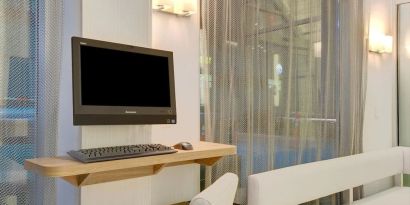 Business center with computer, printer and comfortable seating at Wyndham Garden Brooklyn Sunset Park.