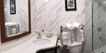 Private guest bathroom with shower and free toiletries at Days Inn By Wyndham Brooklyn Marine Park.