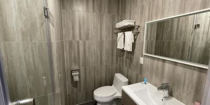 Private guest bathroom with shower and free toiletries at King Hotel Brooklyn.