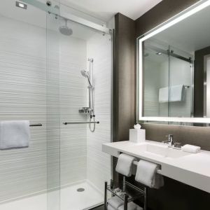 Private guest bathroom with shower and free toiletries at AC Hotel New York Times Square.
