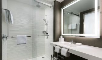 Private guest bathroom with shower and free toiletries at AC Hotel New York Times Square.