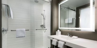 Private guest bathroom with shower and free toiletries at AC Hotel New York Times Square.