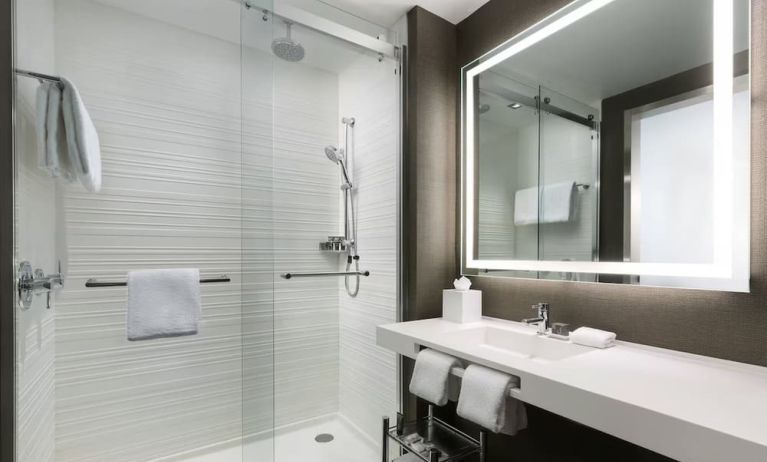 Private guest bathroom with shower and free toiletries at AC Hotel New York Times Square.