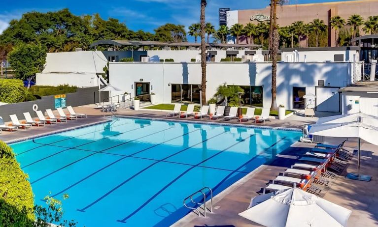 Refreshing outdoor pool surrounded by pool loungers at The Anaheim Hotel.