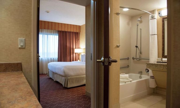 Guest bathroom with tub and shower at Embassy Suites By Hilton Charlotte-Concord-Golf Resort & Spa.