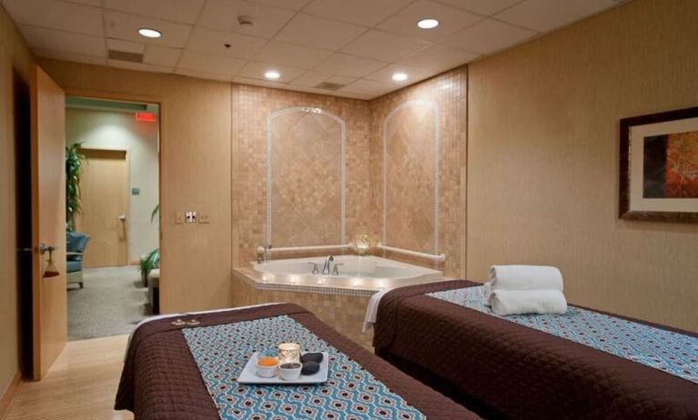 Spa with jacuzzi and massage tables at Embassy Suites By Hilton Charlotte-Concord-Golf Resort & Spa.