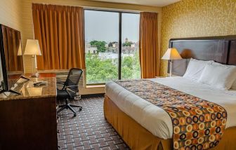 Day use room with king bed, work desk, large windows and private bathroom at Elmhurst Hotel.
