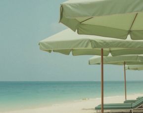 Private beach access with lounge seating and umbrellas at Shelborne South Beach.