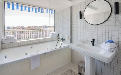 Guest bathroom with tub and natural light at Splendid Hotel & Spa Nice.