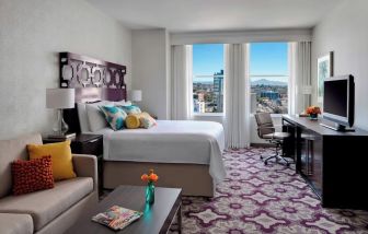 Day use room with TV, work desk, sofa and natural light at Courtyard San Diego Downtown.
