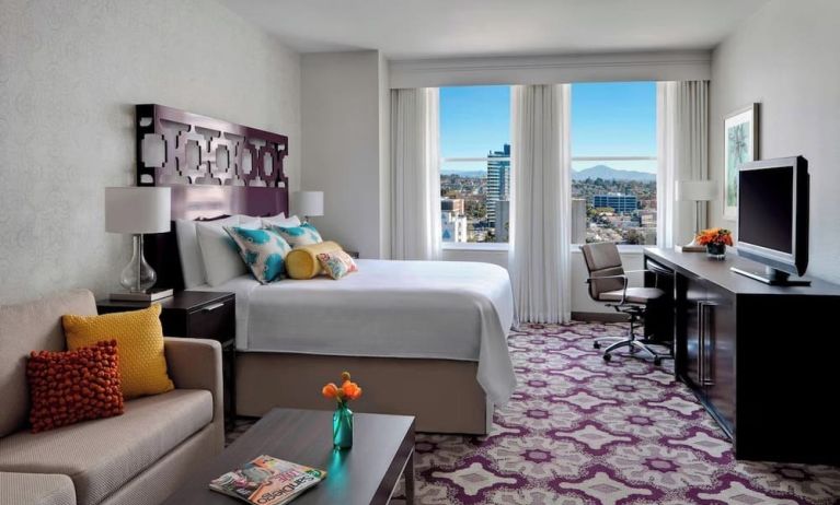 Day use room with TV, work desk, sofa and natural light at Courtyard San Diego Downtown.