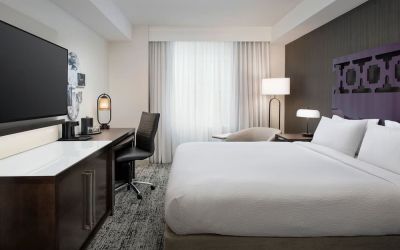 Delux king room with TV, work desk, and natural light at Courtyard San Diego Downtown.
