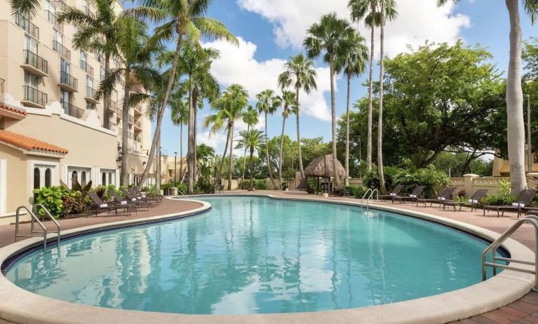 Beautiful outdoor pool with lounge chairs at Embassy Suites By Hilton Miami - International Airport.