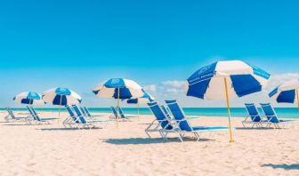 Beach access with lounge seating and umbrellas at The Goodtime Hotel.