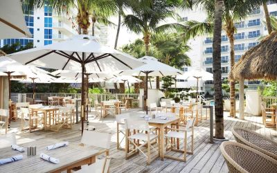 Outdoor lounge and dining area with comfortable seating at Cadillac Hotel & Beach Club, Autograph Collection.