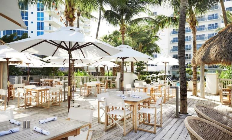 Outdoor lounge and dining area with comfortable seating at Cadillac Hotel & Beach Club, Autograph Collection.