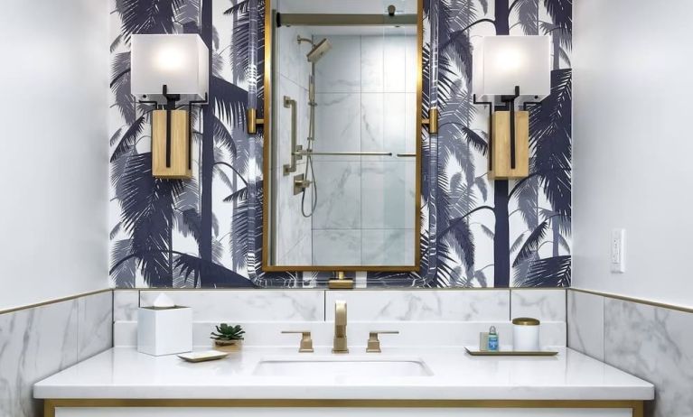 Private guest bathroom with shower and free toiletries at Cadillac Hotel & Beach Club, Autograph Collection.