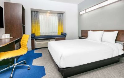 Day use room with TV and work desk at Microtel Inn And Suites By Wyndham Austin Airport.