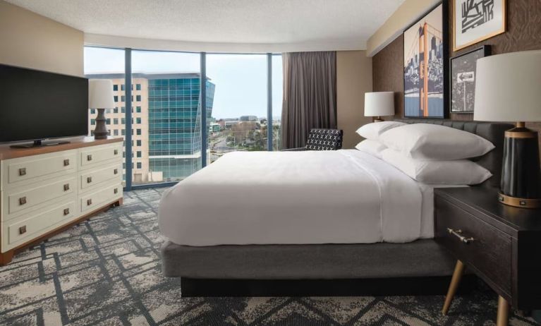 King size bed, TV and large window at Embassy Suites by Hilton San Francisco Airport.