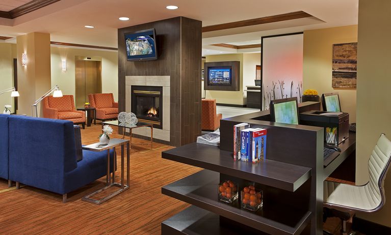 Lobby lounge area with fireplace and business center with computers and printer at Courtyard By Marriott Toronto Airport.