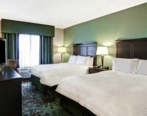 Specious room with 2 size queen beds, TV and window view at the Hampton Inn by Hilton Toronto Airport Corporate Centre.