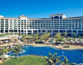 Beautiful outdoors with garden and pool at the Waldorf Astoria Dubai Palm Jumeirah.