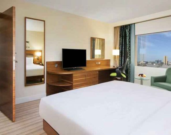 Comfortable queen room with window view and working desk at the Hilton Ras Al Khaimah Beach Resort.