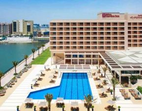 Relaxing outdoor pool area with outstanding creek view at the Hilton Ras Al Khaimah Beach Resort.