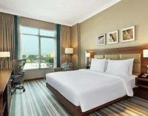 Comfortable King room with king bed, desk, tv and living room area at the Hilton Garden Inn Dubai Al Mina