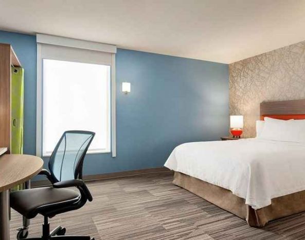 Comfortable king-sized-bed with dedicated workspace at Home2 Suites by Hilton Silver Spring.