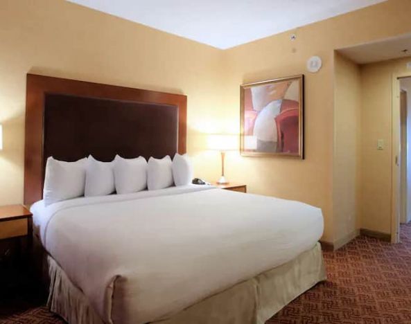 Spacious 2 bedroom suite with a king size bed, desk, tv, and bath at the Embassy Suite by Hilton Charlotte-Concord- Golf Resort & Spa.