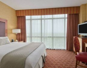 Spacious 2 bedroom suite with a king size bed, desk, tv, and bath at the Embassy Suite by Hilton Charlotte-Concord- Golf Resort & Spa.