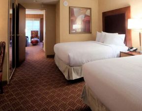 Spacious 2 bedroom suite with two queen beds, desk, tv, and bath at the Embassy Suite by Hilton Charlotte-Concord- Golf Resort & Spa.