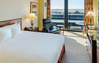 King size suite with king bed, sound proof windows, courch and a view of the runway at the Hilton Chicago O'Hare Airport