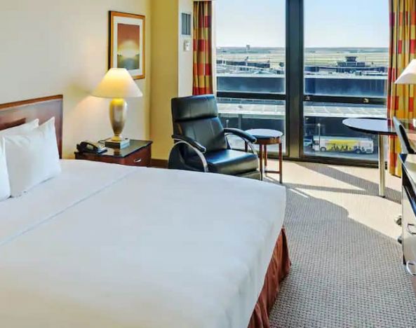 King size suite with king bed, sound proof windows, courch and a view of the runway at the Hilton Chicago O'Hare Airport