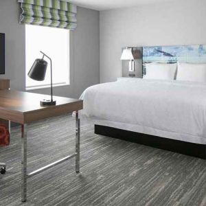 delux king-sized bed with work desk at Hampton Inn Wichita Northwest.
