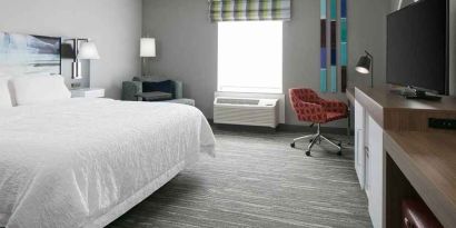 spacious king-sized room with TV and workspace at Hampton Inn Wichita Northwest.
