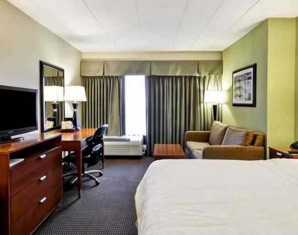 Spacious and bright king guestroom with a large window at the Hampton Inn Chicago-Gurnee.