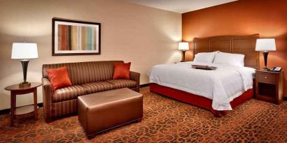 Spacious king-sized bed with lounge area at Hampton Inn Omaha/West-Dodge Road (Old Mill).
