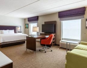 King suite with 1 king bed, couch, desks and tv at the Hampton Inn & Suites Chicago-Libertyville