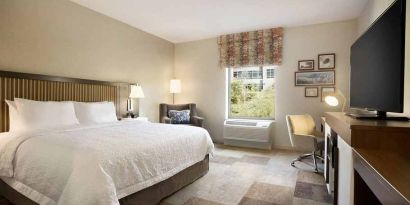 Bright-lit king-sized bed with TV and work desk at Hampton Inn By Hilton, Salt Lake City Cottonwood.