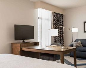 king-sized bed in studio with work desk, TV, and lounge area at Hampton Inn & Suites La Crosse Downtown, WI.