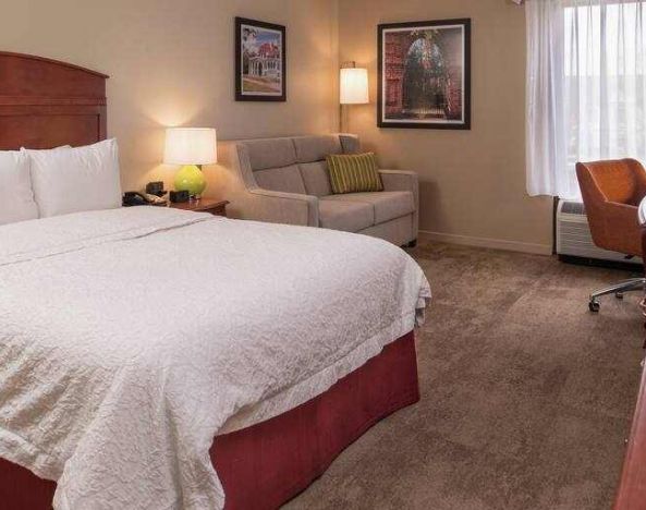 King size bed, sofa and desk in a hotel room at the Hampton Inn Columbia Northeast-Fort Jackson Area, SC.