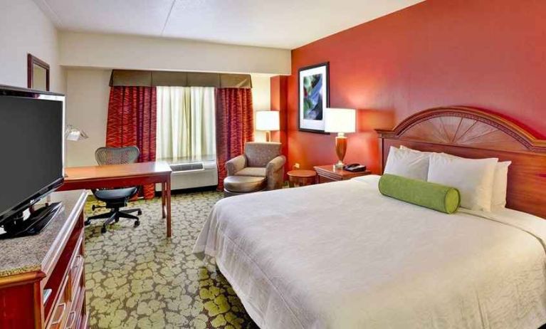 Beautiful king suite with TV, work desk, and lounge area at Hilton Garden Inn Chicago/Midway Airport.