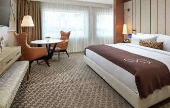 Comfortable king deluxe room with desk and window at the Statler Dallas, Curio Collection by Hilton.