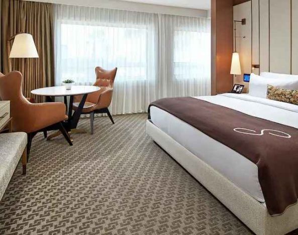 Comfortable king deluxe room with desk and window at the Statler Dallas, Curio Collection by Hilton.